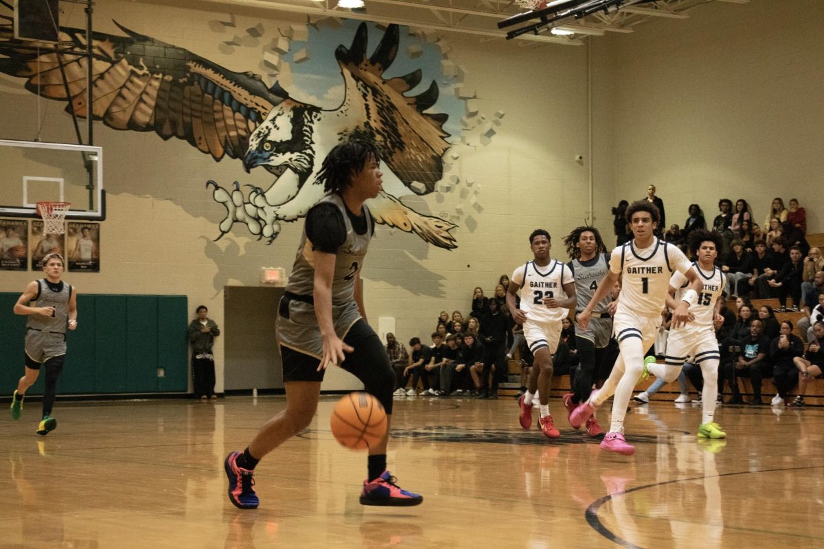 Nelson Marshall dribbling the ball to the other side of the court.