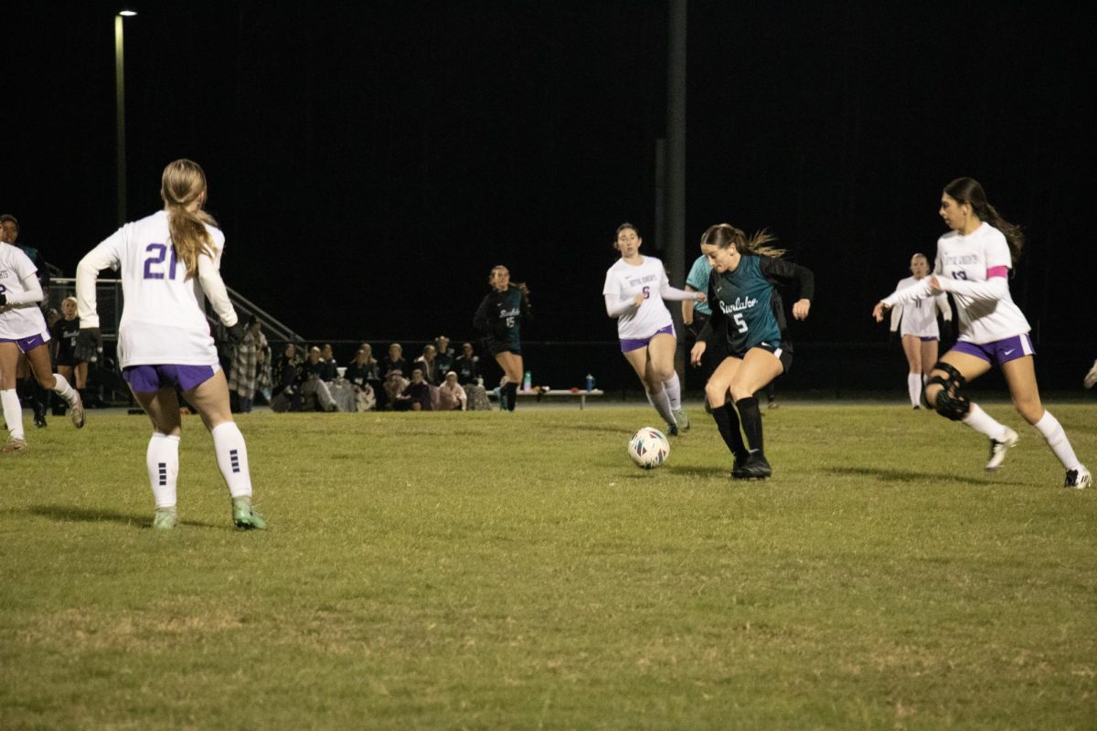 Kylie Hudgins is a junior. She is dribbling up the field in the picture.