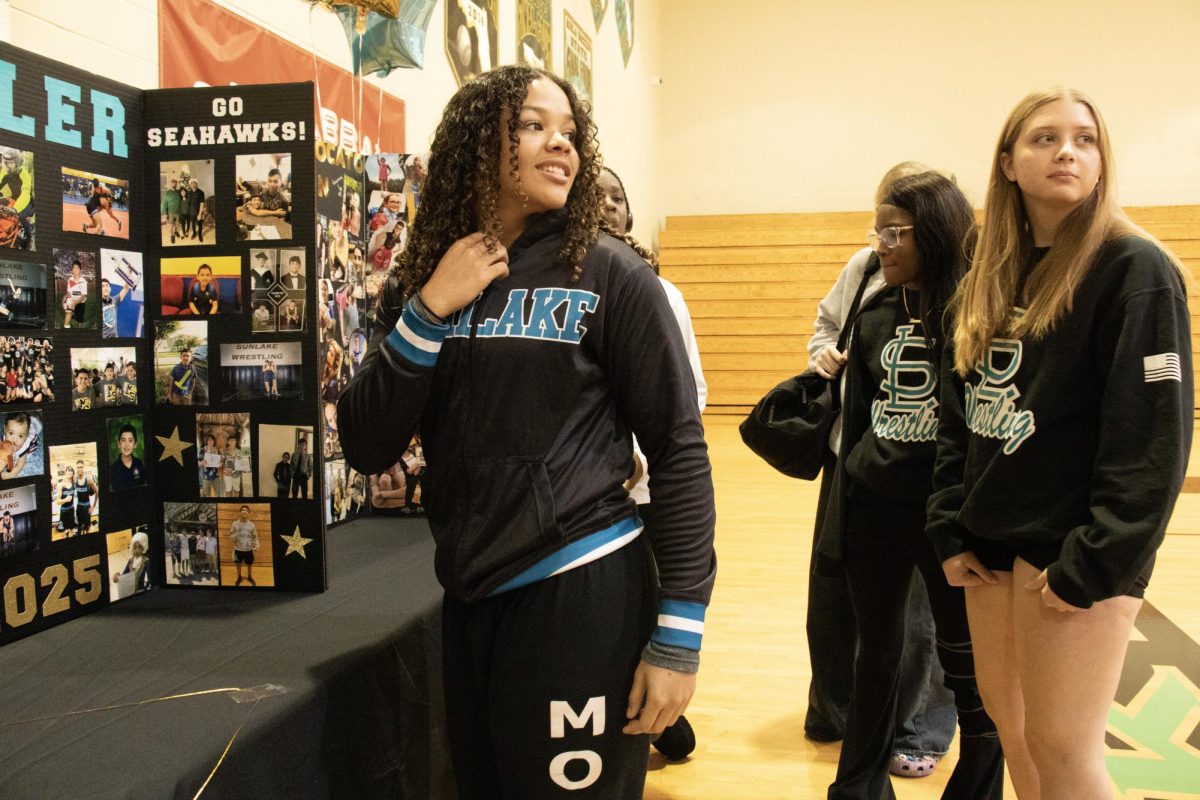 Kirsty More at the Wrestling senior night looking at the senior boards that encapsulate each senior wrestler. 