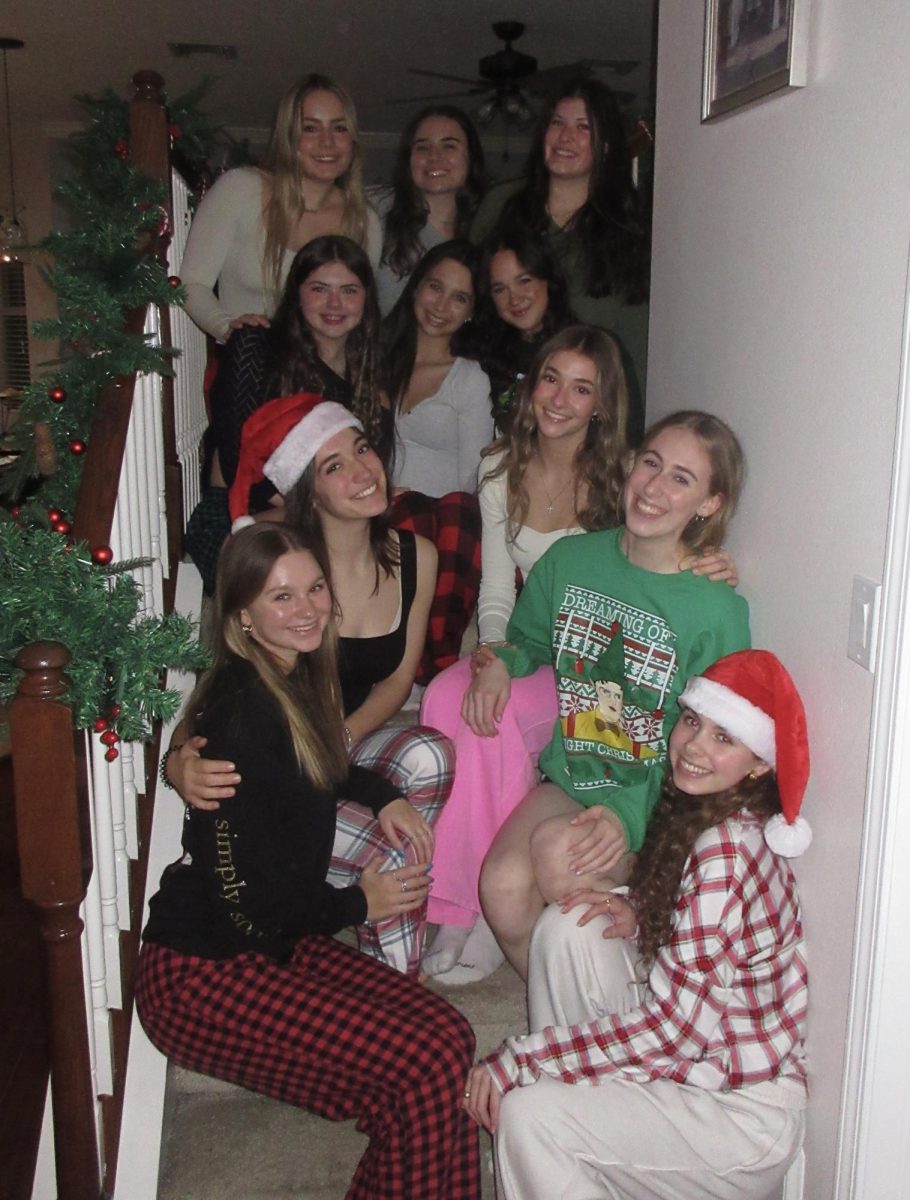 Addison Titchener pictured left with a Santa hat on with her friends at a Christmas Party.