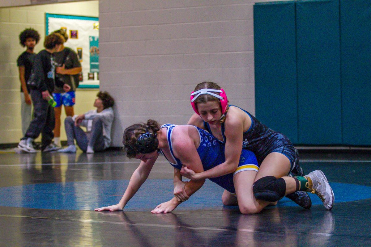 This photo captures a powerful moment in the ring. Cameron Lord, is seen locked on top of her opponent during their fight.