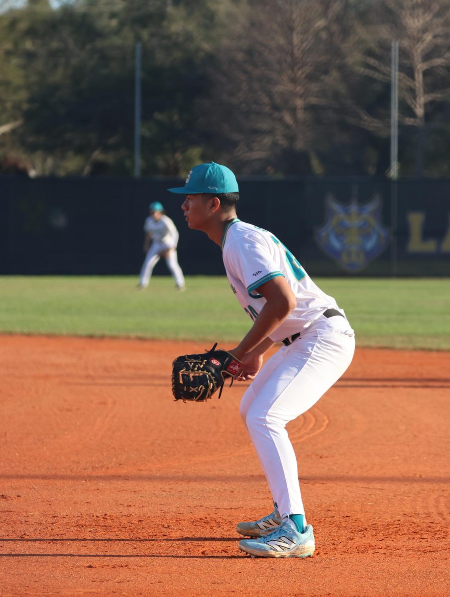 Noah is seen in this photo. he is playing first base. 