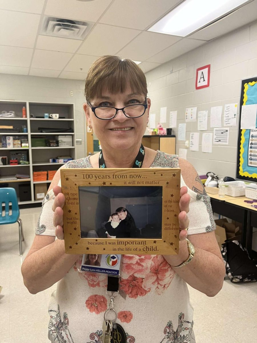 Mrs. Peacock clutching onto a framed photo of her holding her oldest grandson when he was first born. She was holding her grandson, who is now almost 19. In the picture is the first time Mrs. Peacock was able to hold the child.