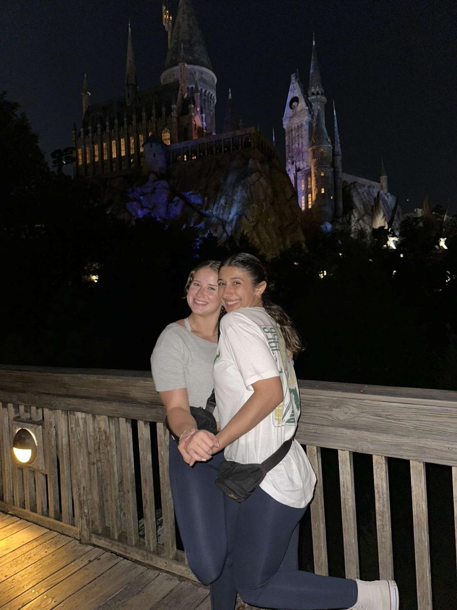 Abby Menard (left) posing for a picture with a friend in front of the Hogwarts building at Universal.