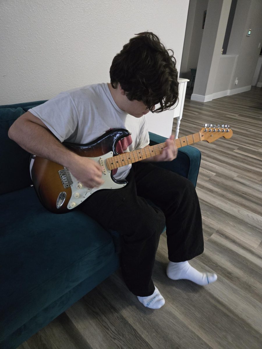 Aiden playing his prized possession – his Stratocaster electric guitar. He got this present from his dad for his birthday, and he will always appreciate it. In this photo, he is playing one of his favorite songs, "Hotel California" by the Eagles.