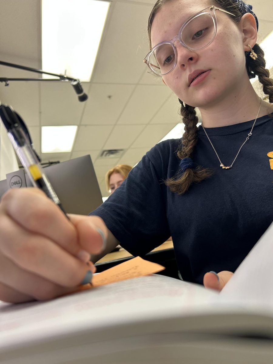 Oriana Caldas writing in her notebook in yearbook. 