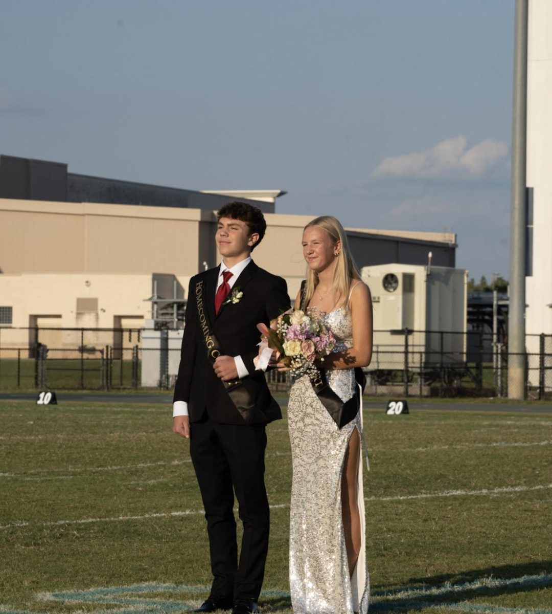 Sara Sidorowicz & Ryder Bagwill walking across the field during the homecoming game. 