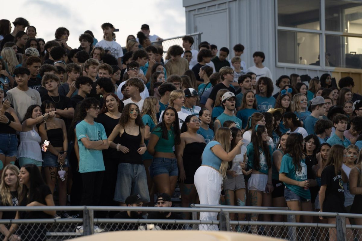 A crowd of students that attended the homecoming football game. The majority are sophomores who are following the coloration theme for each grade.