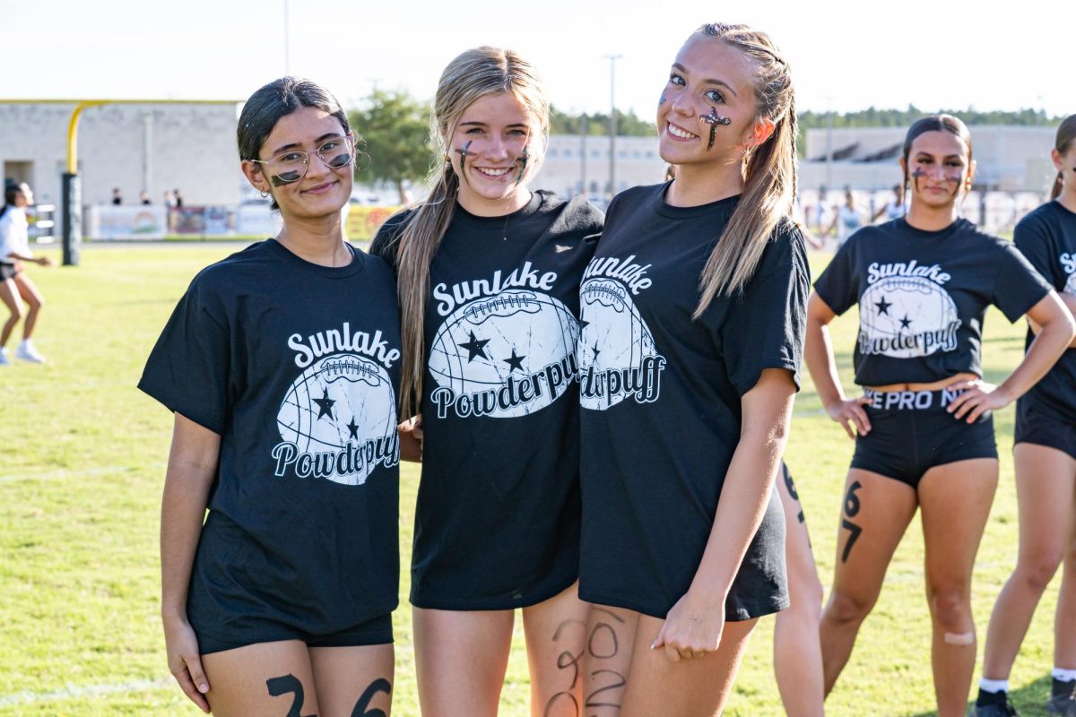 Junior Mia Walter (right) on game day standing with two teammates, Kat Chauchann (left) and Gwyneth Taylor (middle) showing their pride for their school at powderpuff.