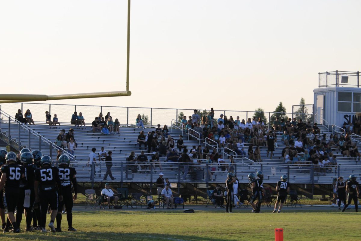 Students, including ... sitting on the bleachers, awaiting for the game to commence.