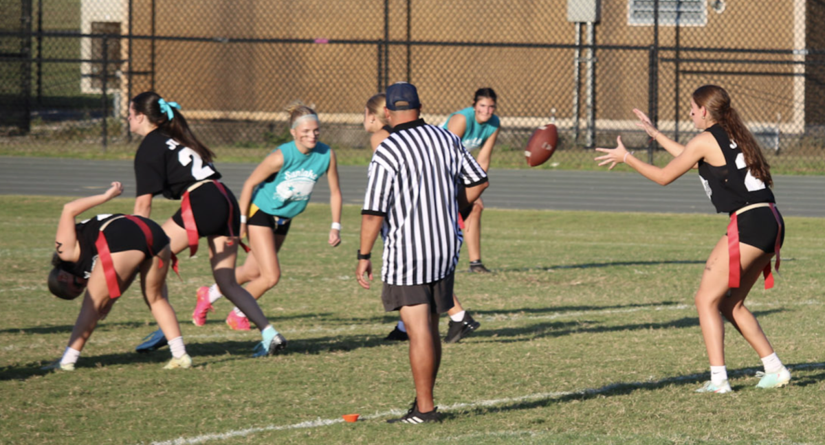 The Sophomore team playing flag football against the Juniors in Powderpuff Football