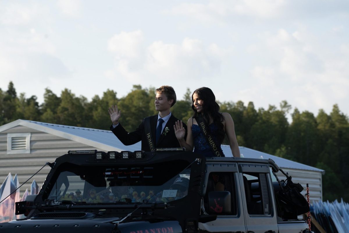 Ian Laari, riding in a Jeep, being announced as homecoming king before Sunlake's homecoming dance.