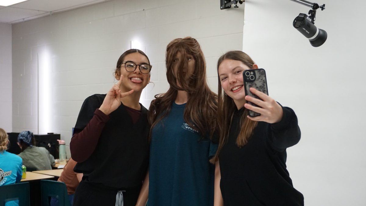 Vanessa Da Silva and Katie Kraszka taking a picture with yearbook mannequin "Bev".