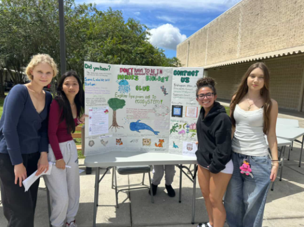 Serafima (far left) pictured with peers next to a posterboard created to promote the biology honors club.
