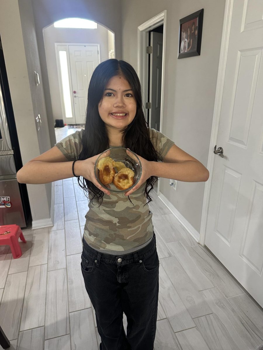 Avery finished baking her dish for friendsgiving, feeling proud of herself. Calling her parents over, she poses with her dish with a big smile.