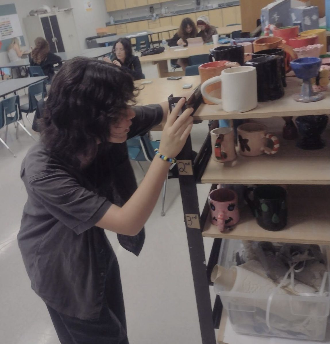 Ninth grader Nina Hackney taking a look at the clay artwork the other students in the Art Club constructed.
