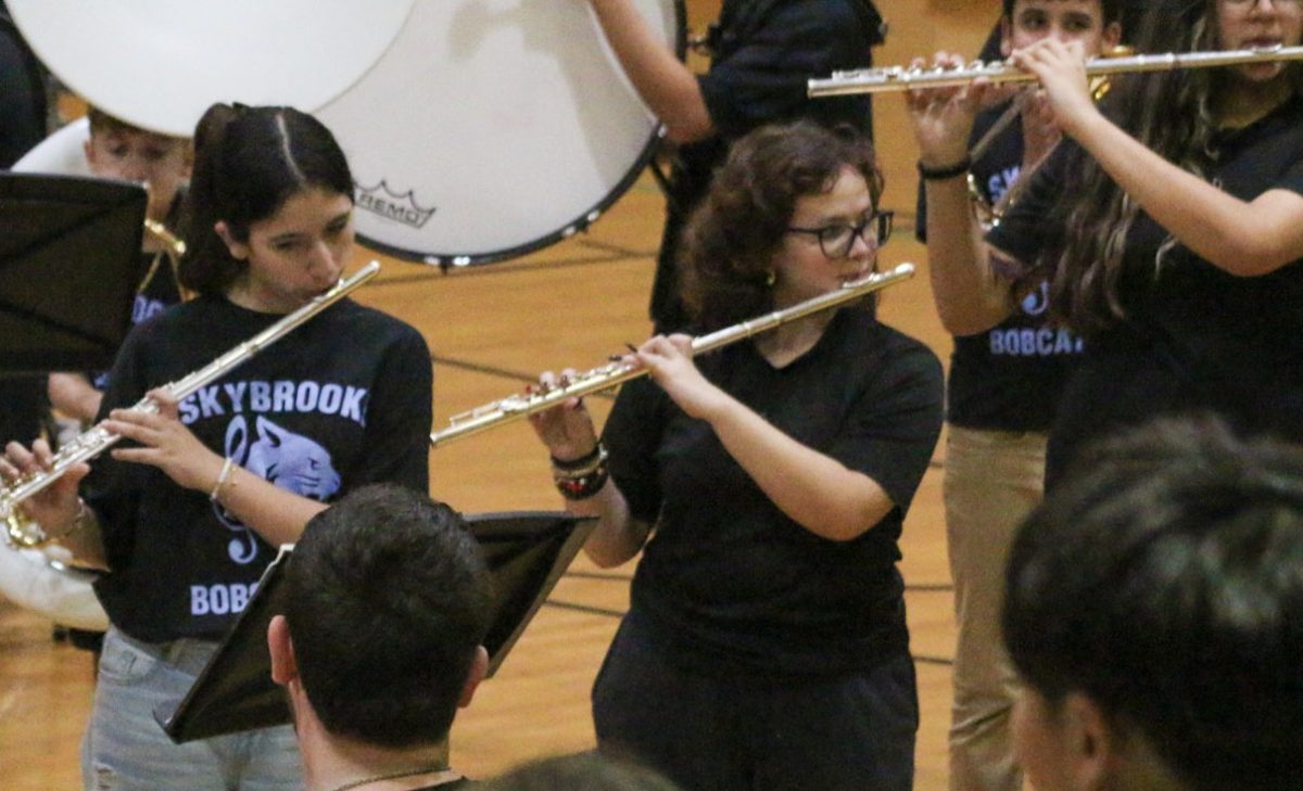 Mary Reyes (right) playing the flute during the marching bad performance.