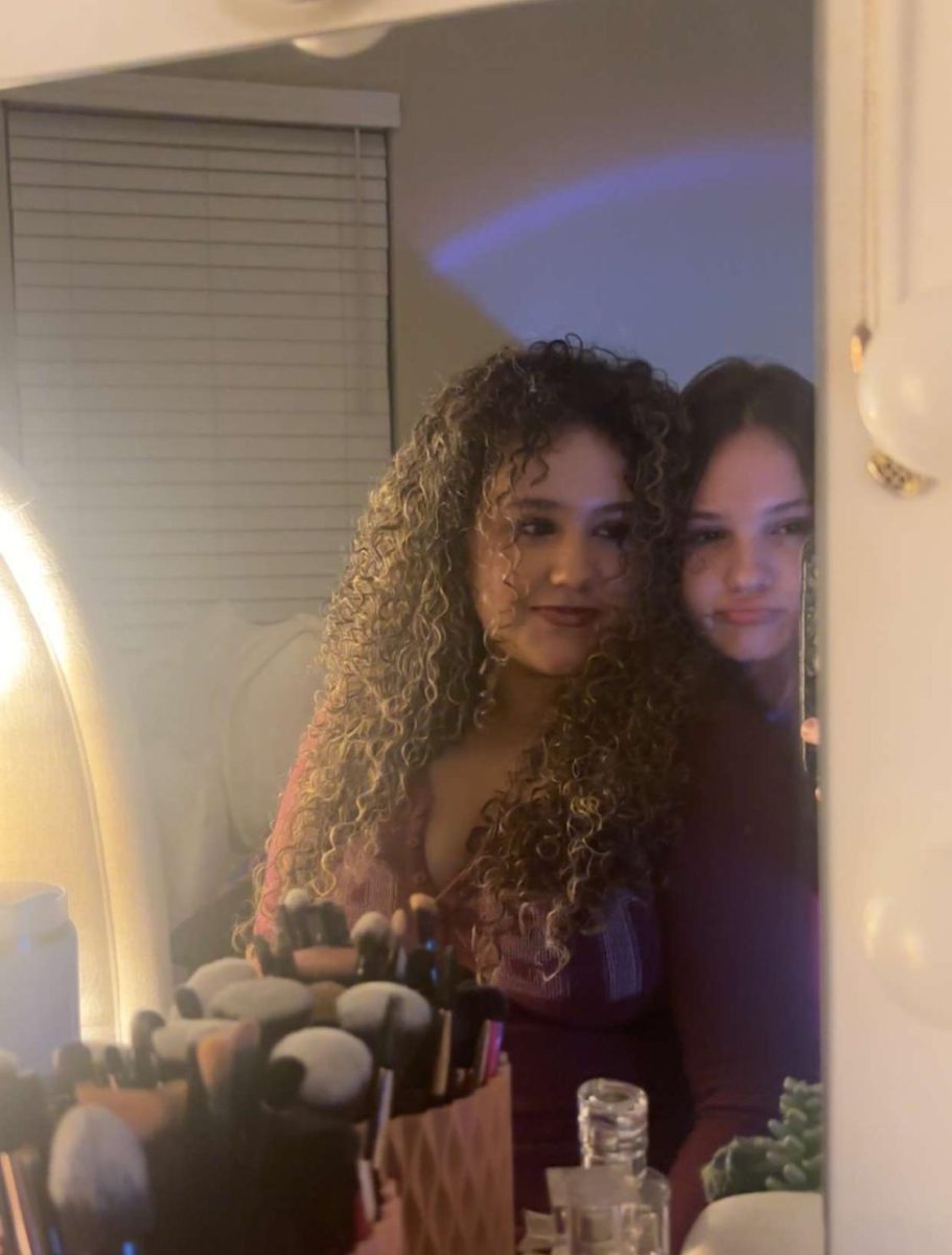Alina gets ready in front of the mirror with her friend, finishing her makeup before going out for New Years. They were getting ready together, talking  and hanging out.