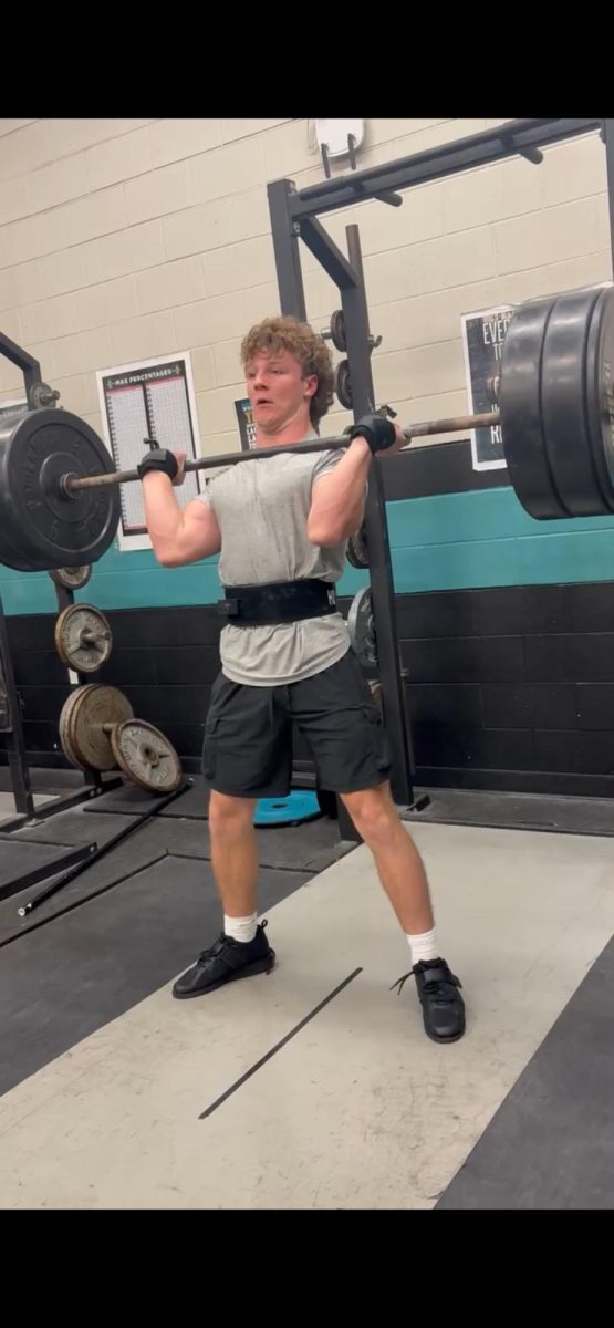 Junior Nathan Merriman;, halfway through a clean and jerk, preparing to raise the bar.
