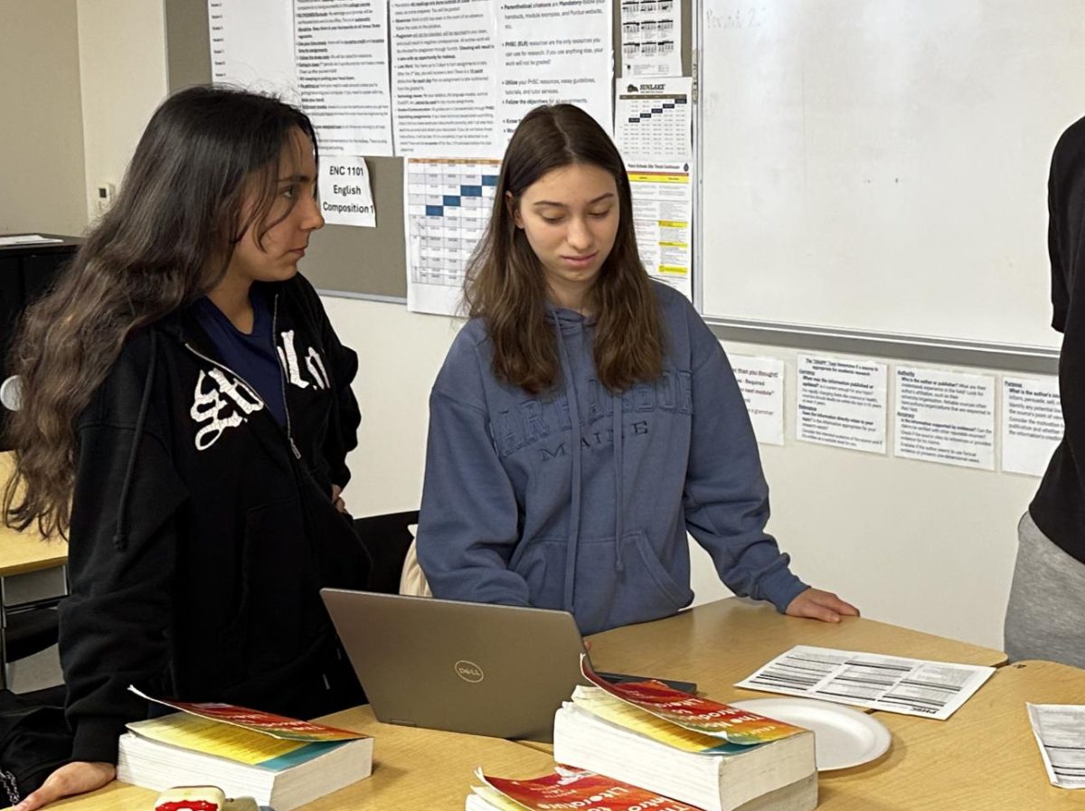 Alex Mualam; Junior, and another Dual Enrollment Club member helping a student figure out dual enrollment classes.