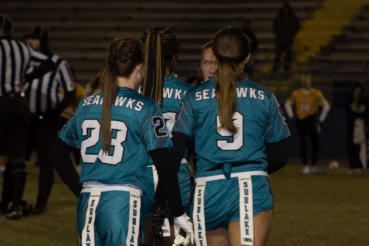 Reese Gerhart #9 stands with her teammates as the Sunlake Seahawks prepare for the next play during their night game.